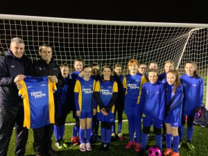 Paul Heaney of Heaney Heating presents a set of jerseys to the Carryduff Ladies U13 team.