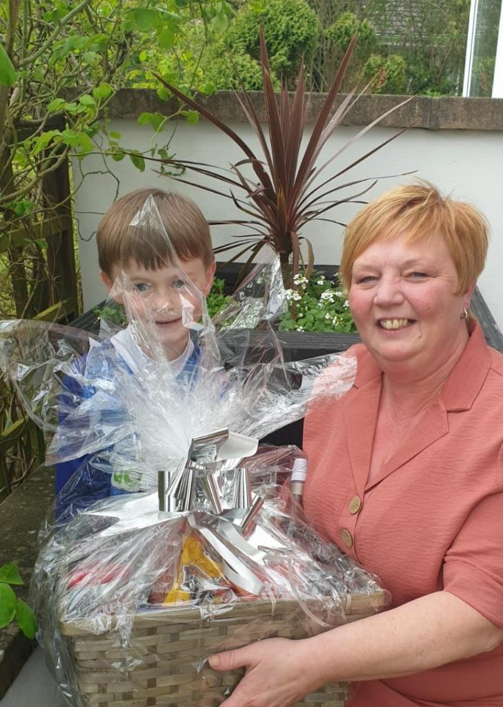 Ryan presenting the hamper to Mrs Rodgers